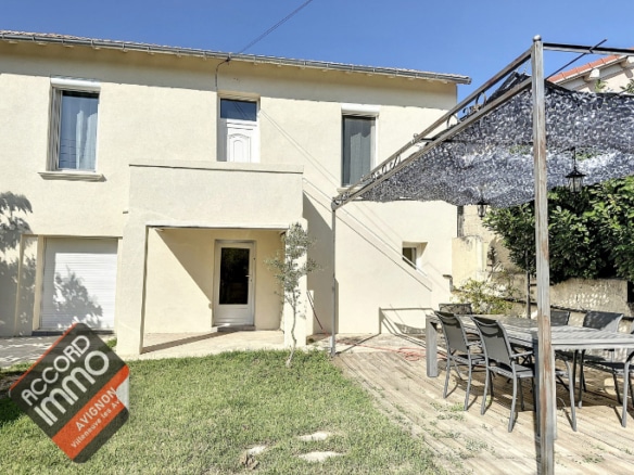 vue de la facade depuis le portail d'entrée et de sa terrasse aménagée