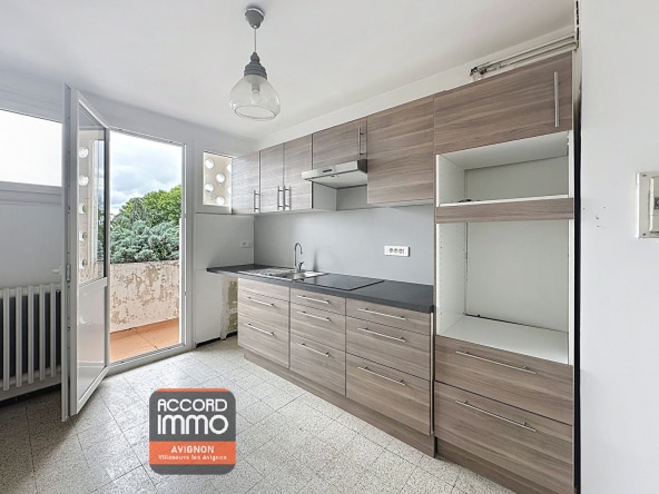 Cuisine équipée avec meubles en bois et accès direct au balcon – vente appartement T3 à Avignon Préfecture