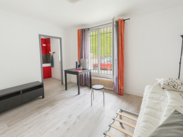 Salon lumineux avec coin bureau et grande fenêtre donnant sur rue, dans un studio à vendre à Avignon secteur Saint-Ruf