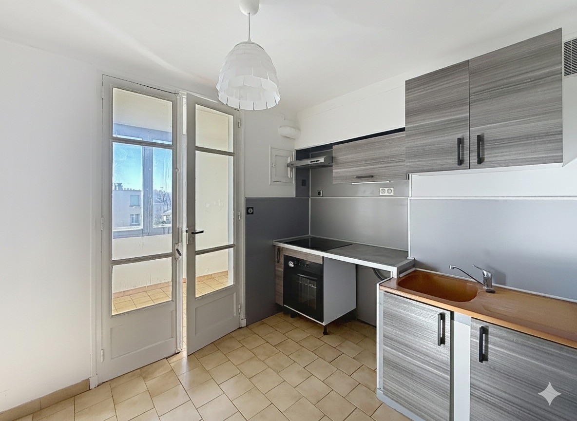 La photo dévoile la cuisine de l'appartement à Avignon, configurée en semi-ouverte. Elle est équipée de rangements et donne accès à une loggia
