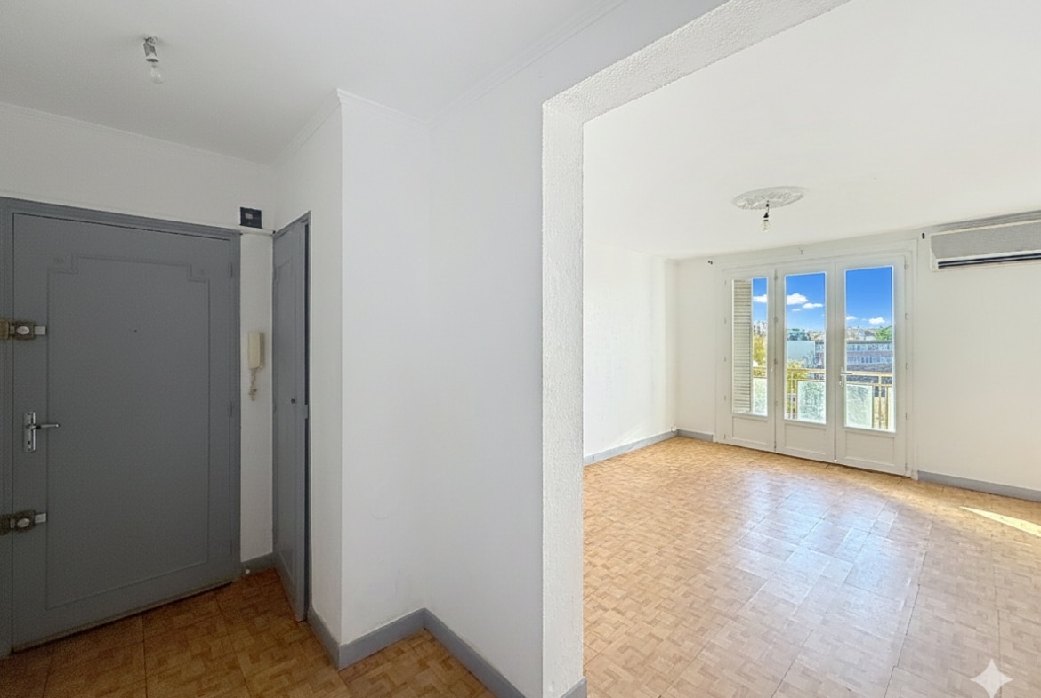 Vue de l'entrée menant au séjour spacieux de l'appartement T3 à Avignon. Le sol est en parquet et la pièce principale est très lumineuse