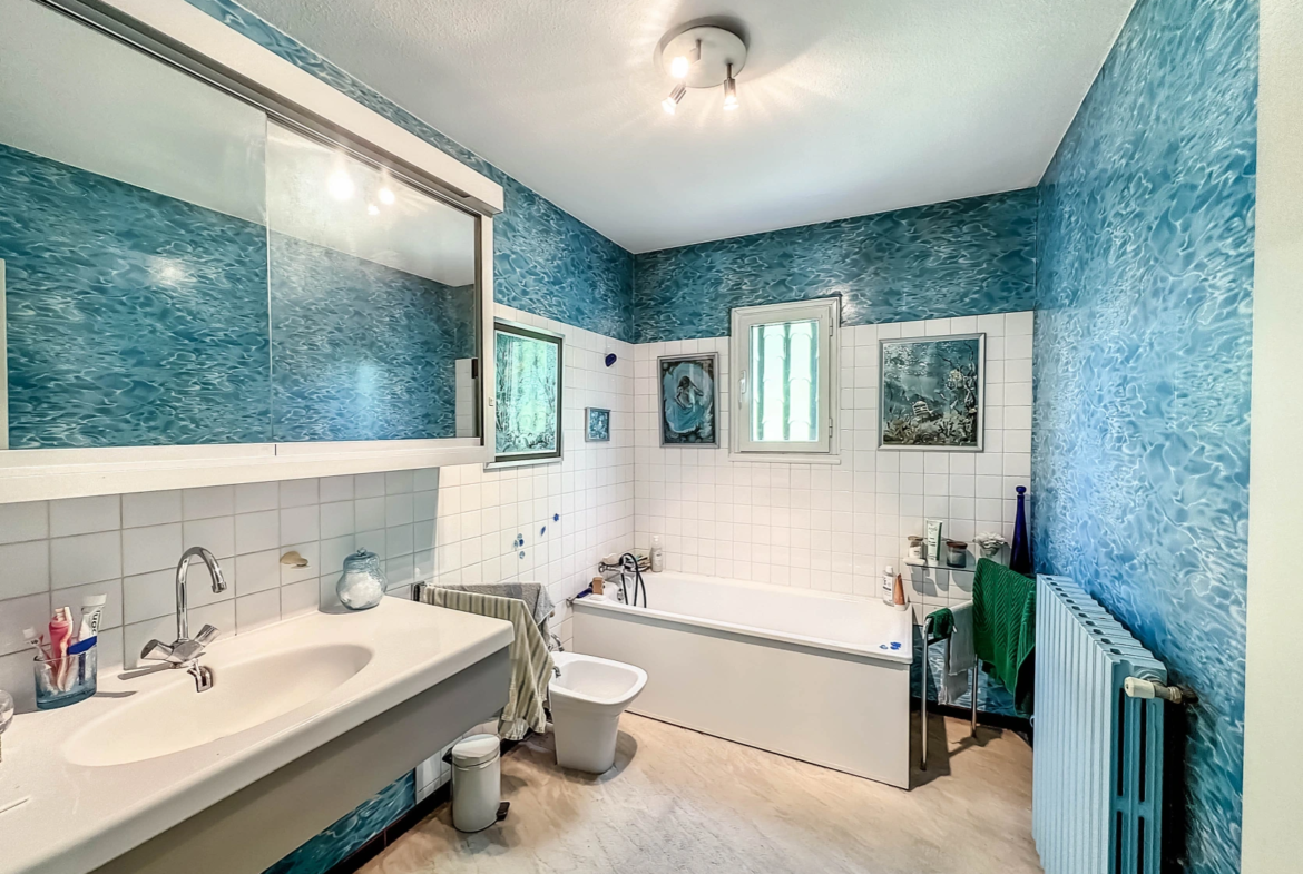 Salle de bains bleu avec baignoire et lavabo au premier étage