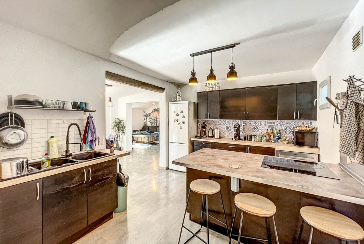 vue de la cuisine aménage moderne et équipée avec son ilot pour manger en cuisine