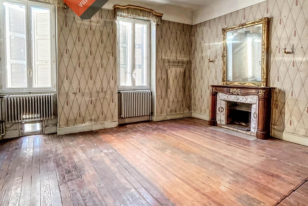 vue du salon avec sa cheminée 1900 dans maison bourgeoise proposé par ACCORD IMMO