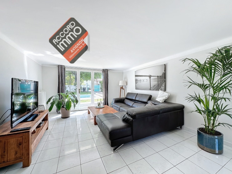 Salon avec canapé et télé au rez de chaussée donnant sur la piscine