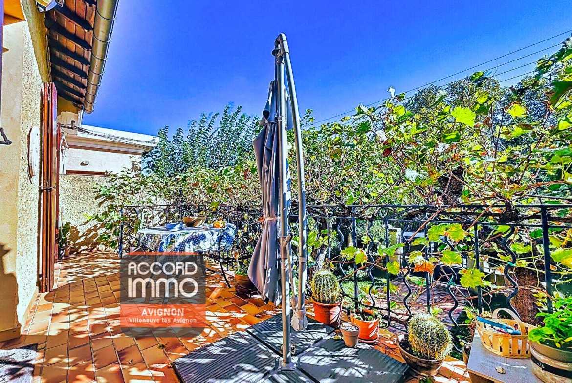 Terrasse arborée et parasol.