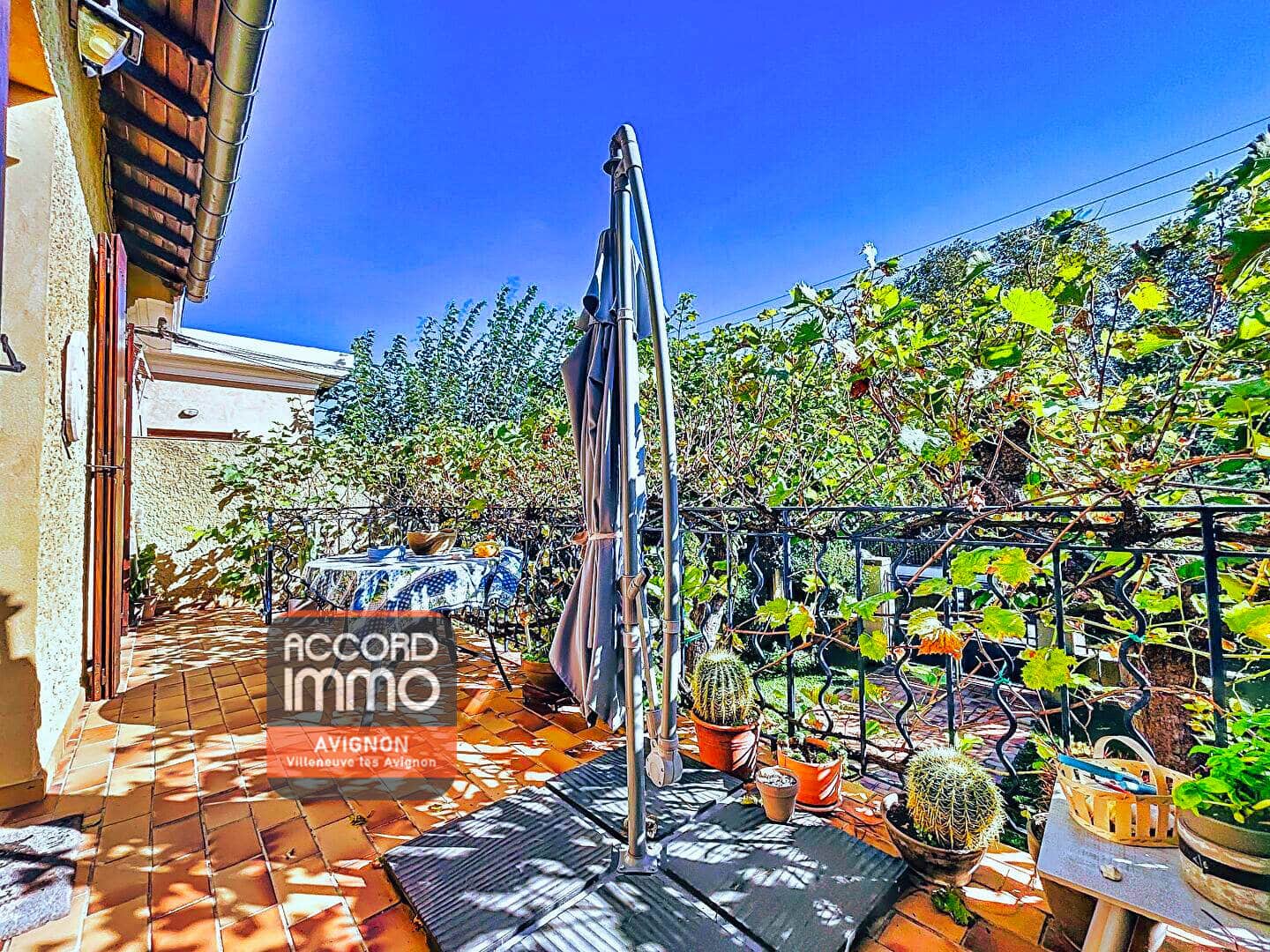 Terrasse arborée et parasol.