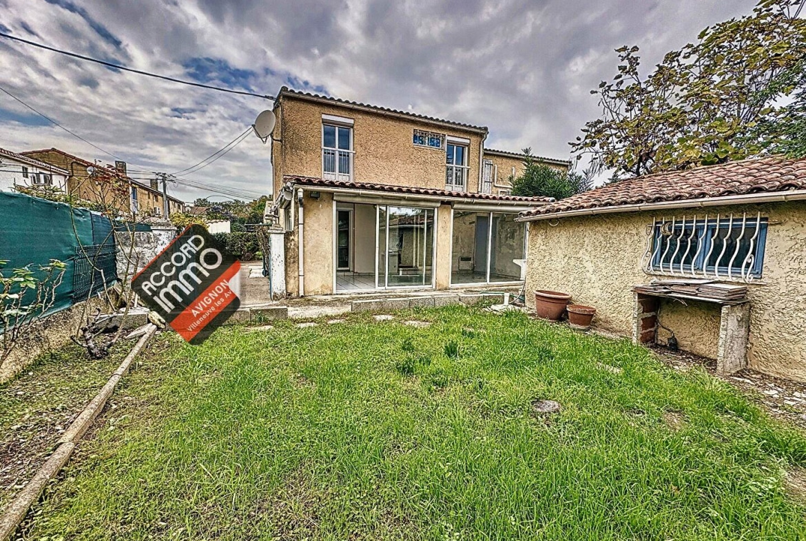 Vue extérieure d'une maison avec jardin, terrasse et dépendances, située au Pontet, maison en vente.