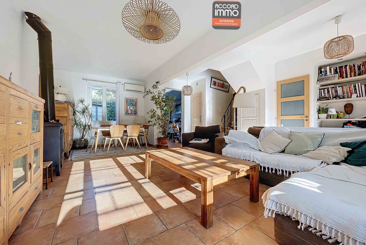 Salon avec carrelage au sol et espace salle à manger, doté de baies vitrées offrant une vue sur le jardin
