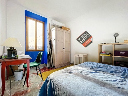 Cette photo montre une chambre spacieuse et lumineuse avec une grande fenêtre en bois, située dans une maison ancienne à Avignon, avenue Pierre Sémard