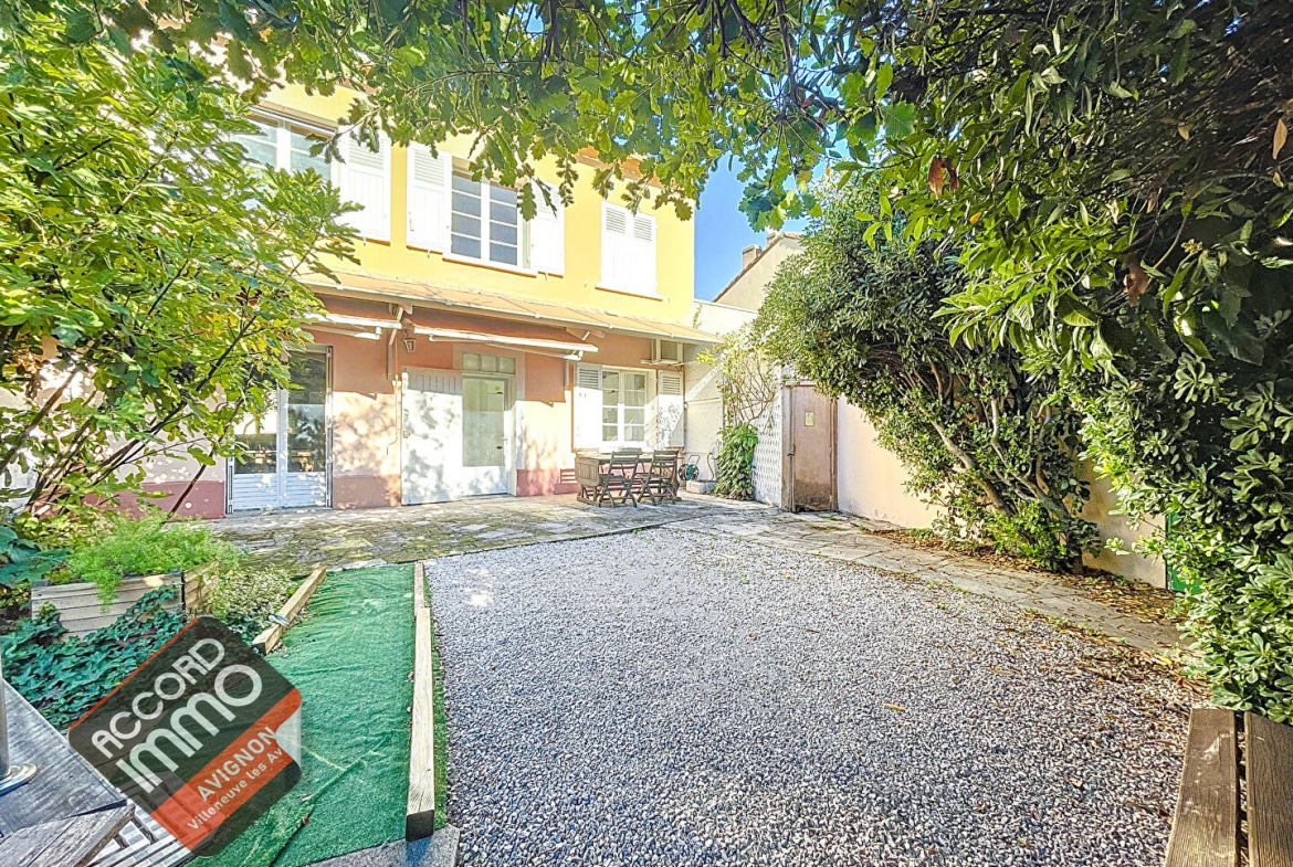 Extérieur d'une maison située dans le quartier Trillade à Avignon, comprenant un jardin arboré et une allée gravillonnée