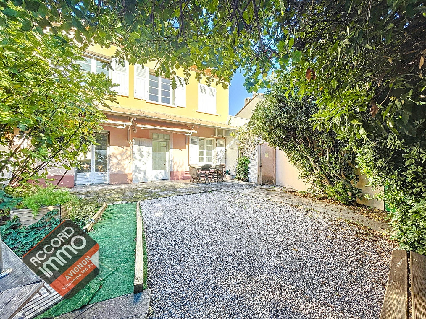 Extérieur d'une maison située dans le quartier Trillade à Avignon, comprenant un jardin arboré et une allée gravillonnée
