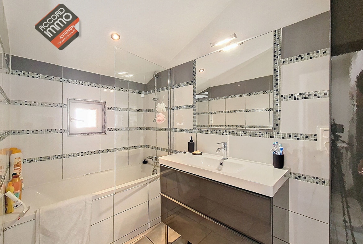Salle de bain contemporaine d’un appartement T3 à vendre à Morières-lès-Avignon, avec baignoire, meuble vasque design et carrelage mosaïque