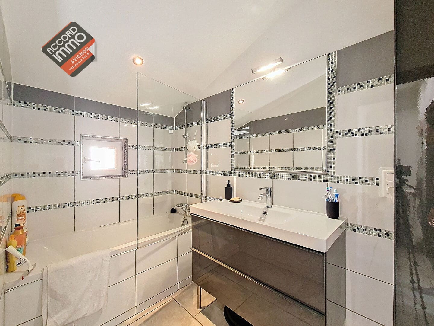 Salle de bain contemporaine d’un appartement T3 à vendre à Morières-lès-Avignon, avec baignoire, meuble vasque design et carrelage mosaïque