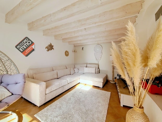 Salon lumineux avec poutres apparentes d’une maison en vente à Vedène. Ambiance chaleureuse, décoration naturelle, idéalement situé près du golf et d’une piscine.