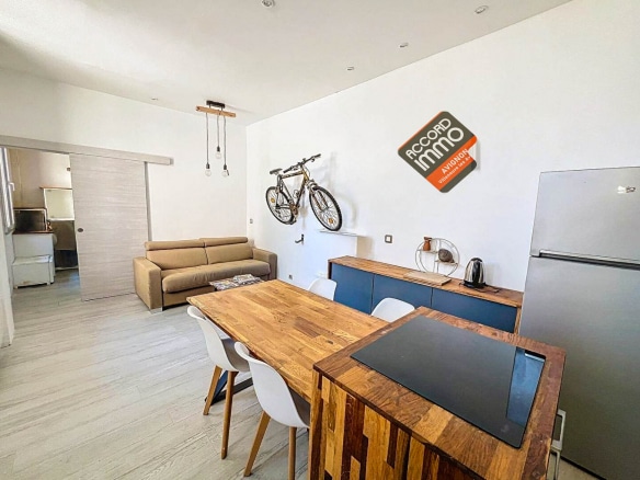 Salon avec canapé, table à manger en bois et rangements dans une maison T2 près des remparts d'Avignon.