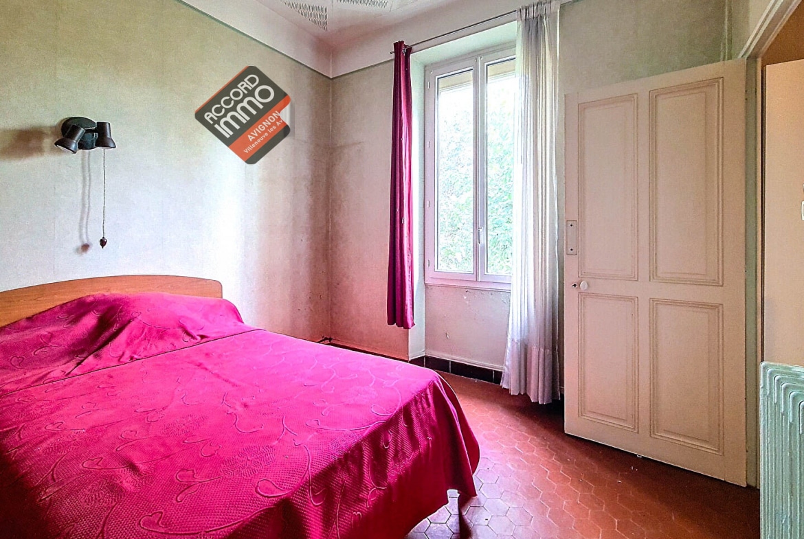 Chambre lumineuse avec lit double, située dans une maison à vendre à Avignon proche des remparts.