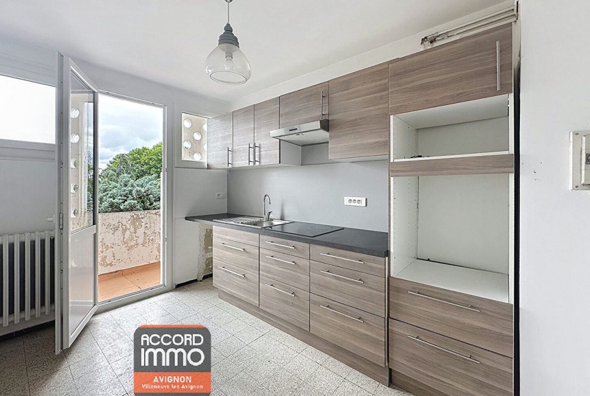 Cuisine équipée avec meubles en bois et accès direct au balcon – vente appartement T3 à Avignon Préfecture
