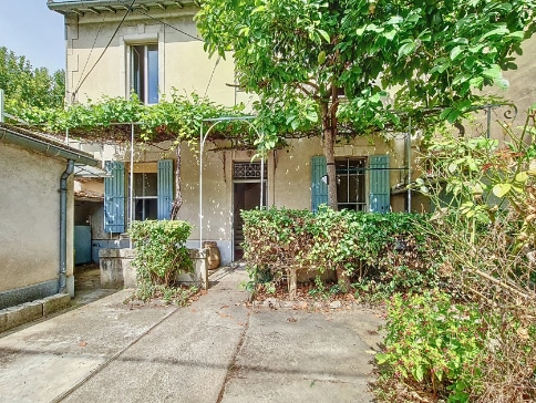 Maison ancienne avec cour arborée à vendre à Avignon - façade avec volets bleus et végétation