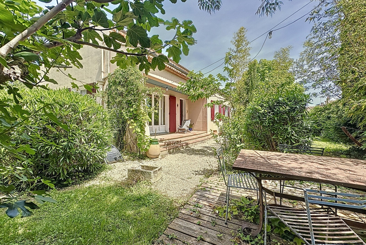 Espace extérieur avec table, chaises et barbecue dans le jardin d'une maison proche d'Avignon