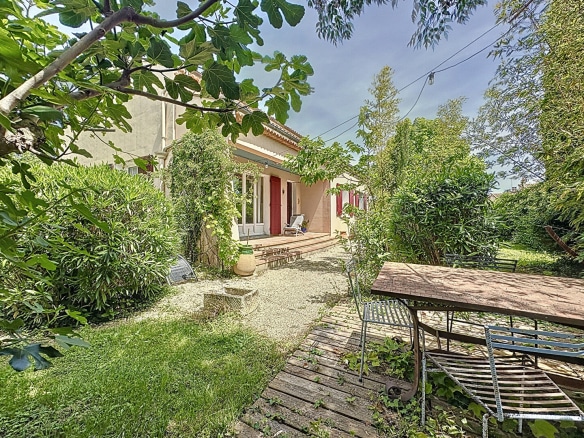 Espace extérieur avec table, chaises et barbecue dans le jardin d'une maison proche d'Avignon