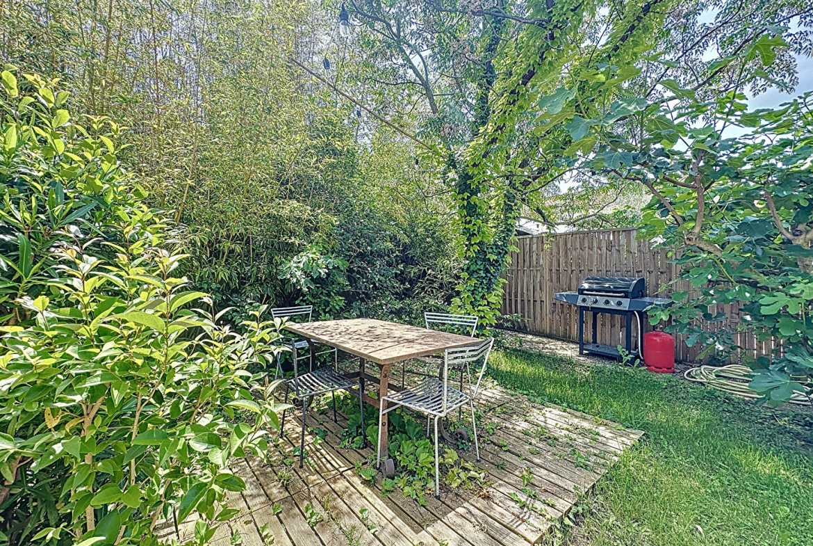 Espace extérieur avec table, chaises et barbecue dans le jardin d'une maison proche d'Avignon
