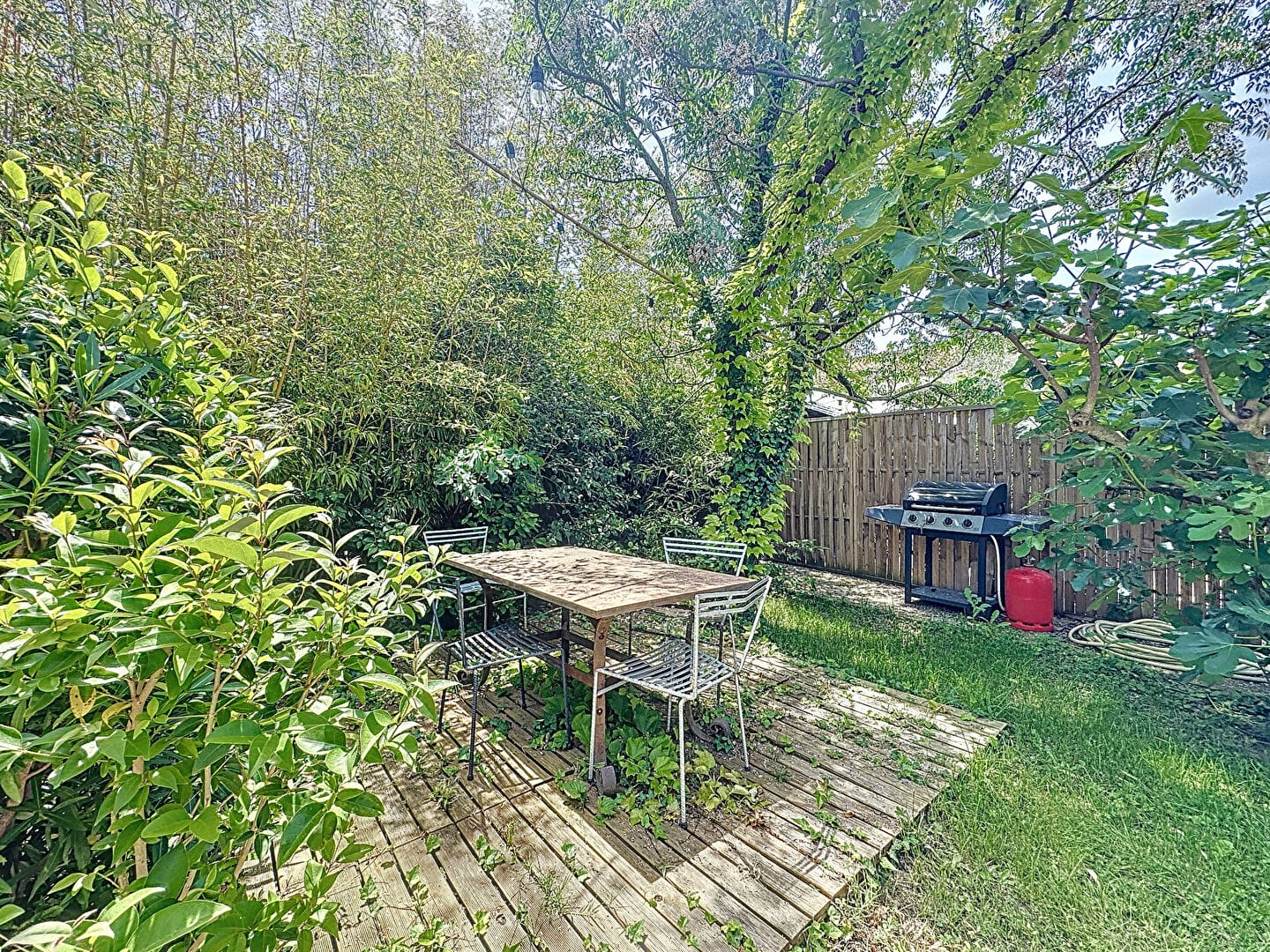 Espace extérieur avec table, chaises et barbecue dans le jardin d'une maison proche d'Avignon