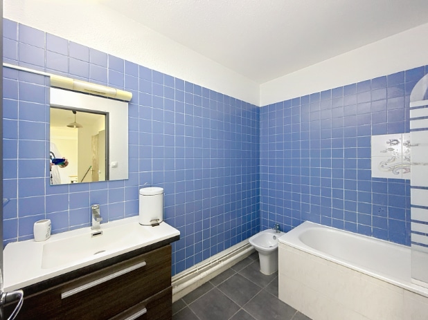 Salle de bain carrelée bleue avec baignoire et vasque, appartement T3 vente Saint-Ruf Avignon