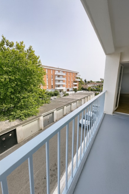 Balcon donnant sur la rue et les espaces verts, situé au deuxième étage d’un appartement T4 à Avignon extramuros