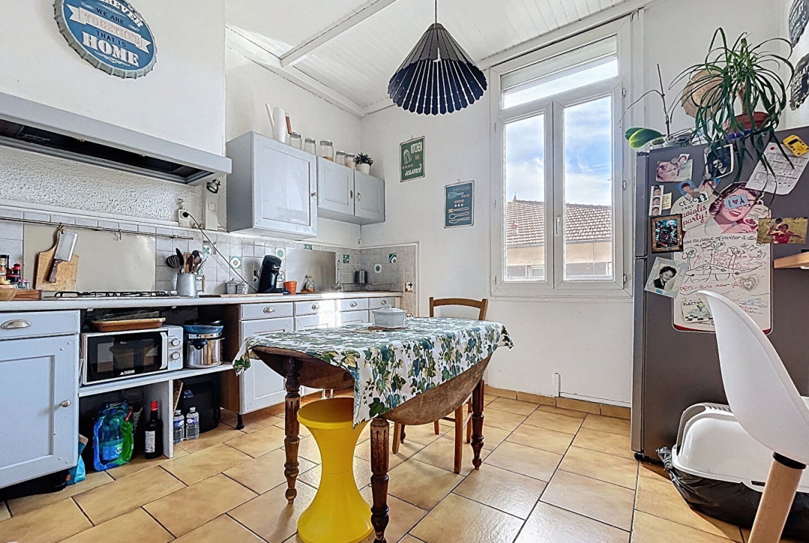 Cuisine claire avec coin repas dans un appartement T4 du quartier Préfecture à Avignon