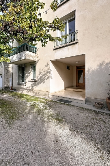 Entrée d’un petit immeuble avec balcon et parking à Avignon, secteur première ceinture extramuros