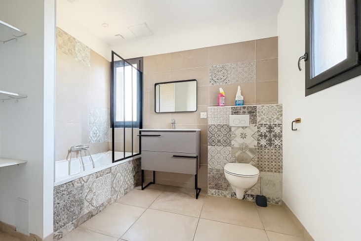 Salle de bain design avec carrelage décoratif et baignoire dans une maison contemporaine à Vacqueyra