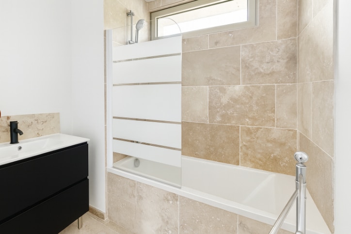 Salle de bain claire avec carrelage beige et meuble vasque noir, quartier La Croisière à Avignon