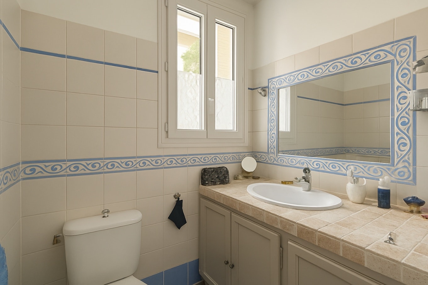 Salle de bain claire avec miroir encadré et fenêtre dans une maison à vendre à Avignon