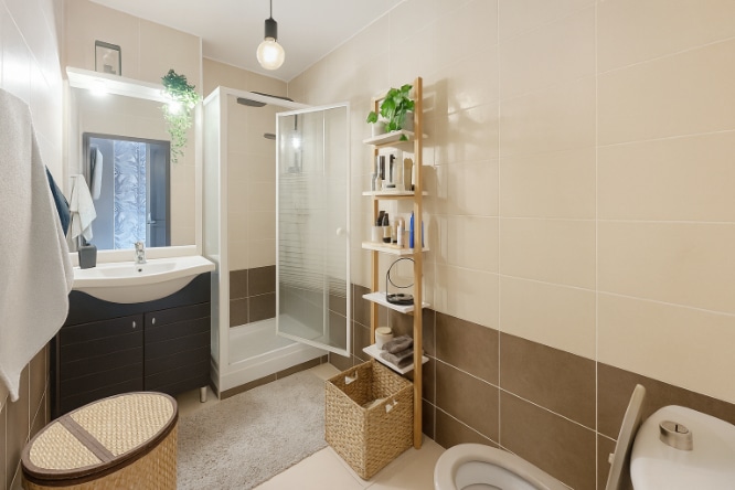 Salle d’eau carrelée avec douche vitrée, vasque et rangements intégrés à Aramon