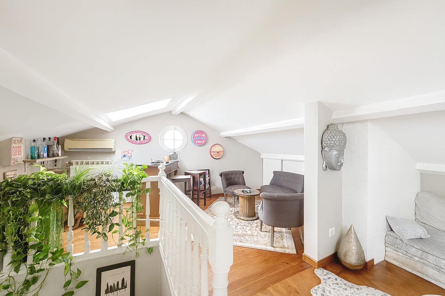 Espace détente sous combles avec fauteuils et poutres apparentes dans une maison à vendre à Avignon