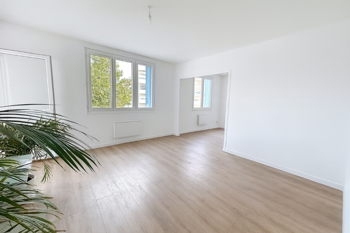 Salon lumineux avec trois fenêtres et parquet clair dans un appartement T4 à vendre à Avignon extramuros