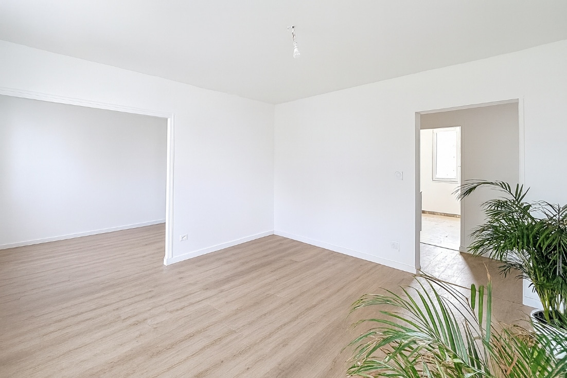 Pièce principale lumineuse avec double ouverture et parquet clair dans un appartement T4 à vendre à Avignon