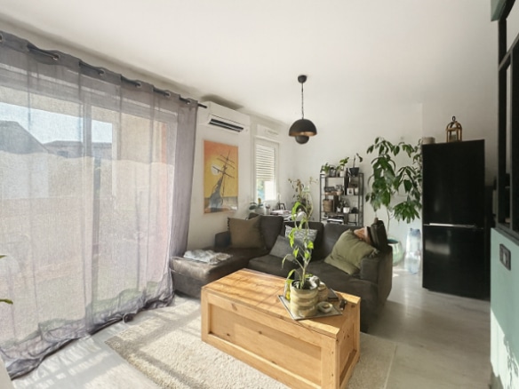 Salon moderne avec canapé, baie vitrée et ouverture sur la terrasse dans un appartement à Aramon