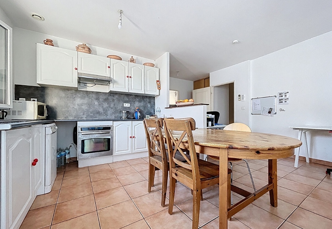 Cuisine aménagée avec coin repas en bois dans une maison à vendre à Avignon, quartier des Rotondes