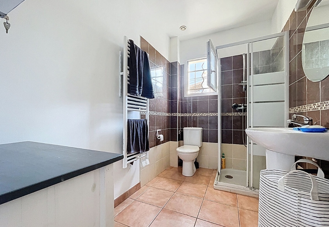 Salle d’eau moderne avec douche et toilettes dans une maison à Avignon occupée par un locataire