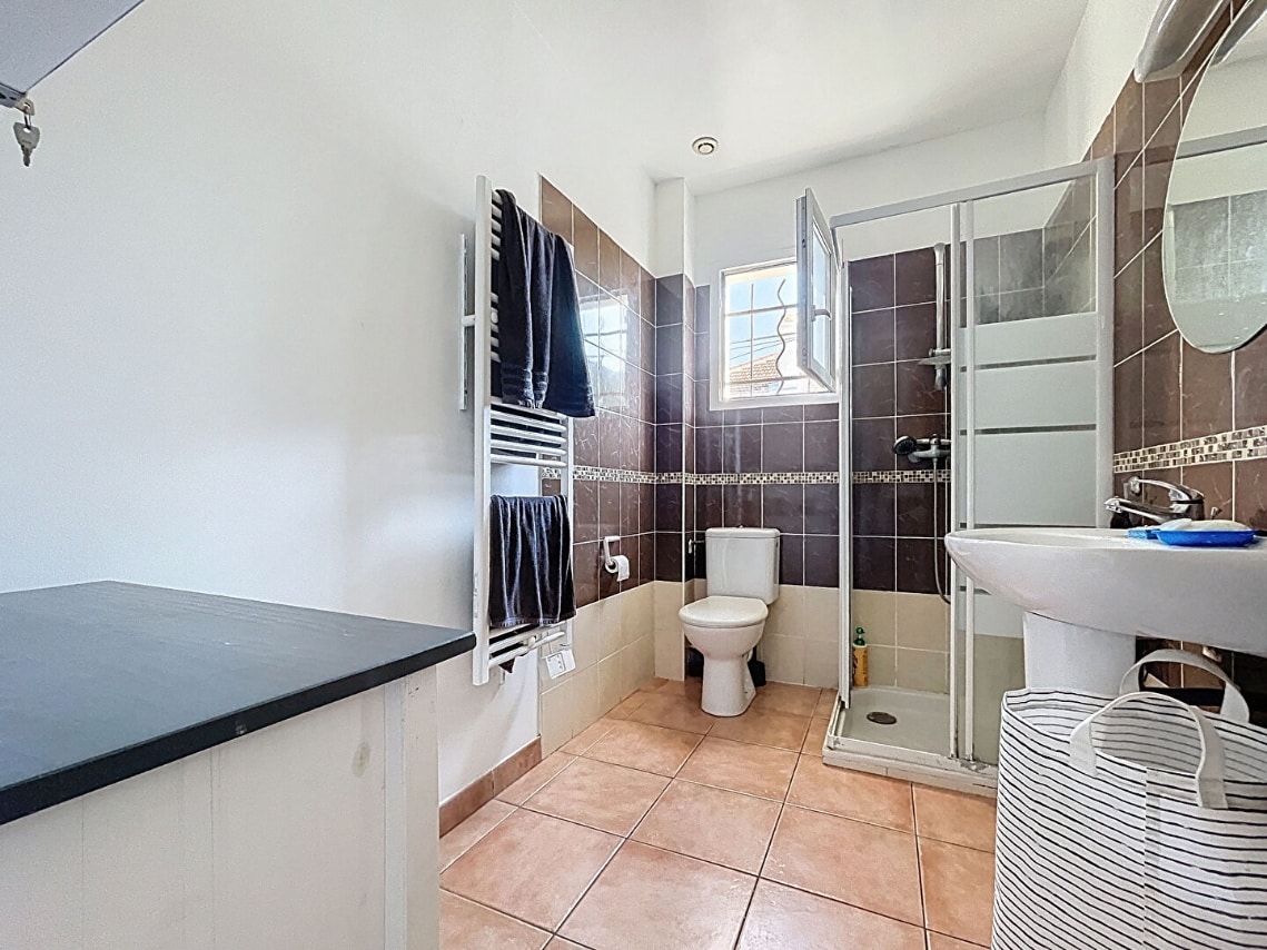 Salle d’eau moderne avec douche et toilettes dans une maison à Avignon occupée par un locataire