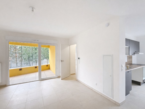 Séjour lumineux avec carrelage beige donnant accès à loggia de 5 m² et cuisine ouverte équipée. Location T2 de 46 m² à Montfavet proche Cristole avec parking extérieur inclus et chauffage collectif