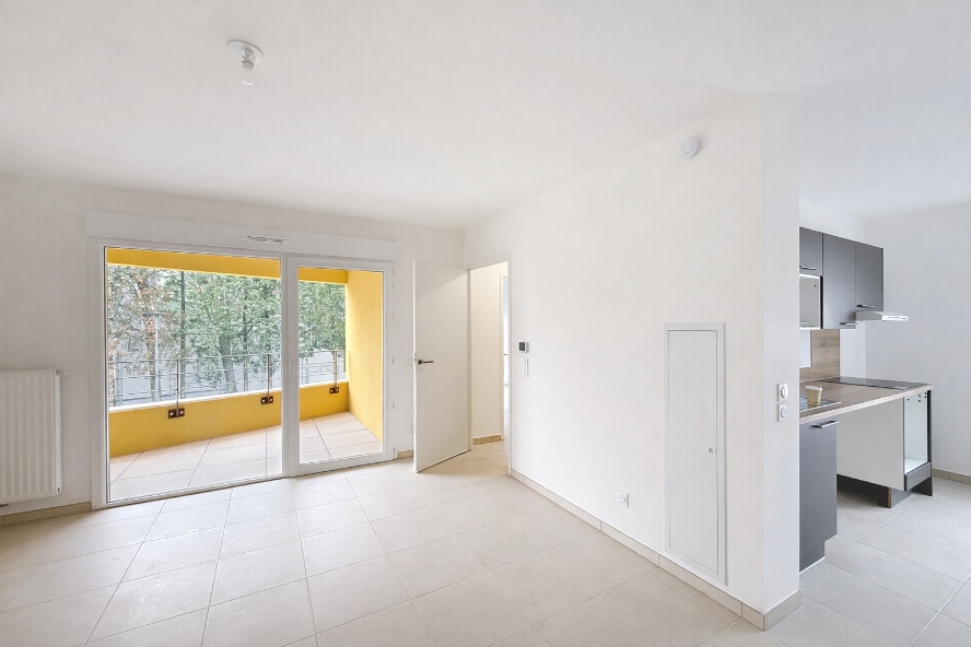 Séjour lumineux avec carrelage beige donnant accès à loggia de 5 m² et cuisine ouverte équipée. Location T2 de 46 m² à Montfavet proche Cristole avec parking extérieur inclus et chauffage collectif
