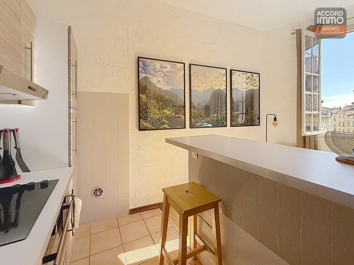 Séjour orienté sud avec fenêtre à huisserie bois, sol en carrelage ou parquet et murs clairs. Espace polyvalent accueillant coin salon et zone repas, hauteur sous plafond standard.