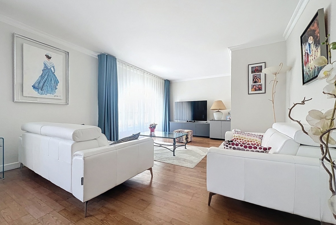 Salon avec canapé et mobilier disposés face aux fenêtres laissant entrer la lumière naturelle. Pièce à vivre d'un duplex situé quartier La Balance à Avignon.