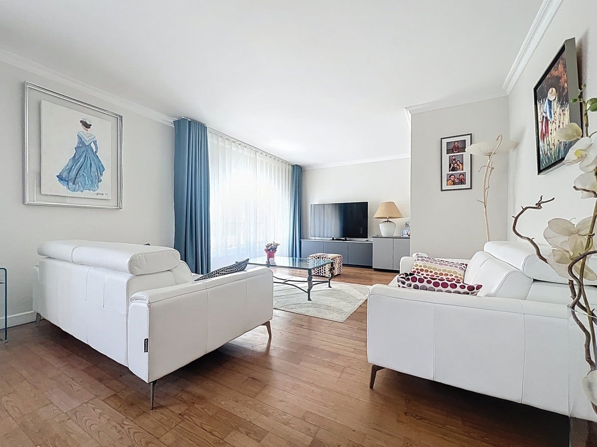 Salon avec canapé et mobilier disposés face aux fenêtres laissant entrer la lumière naturelle. Pièce à vivre d'un duplex situé quartier La Balance à Avignon.