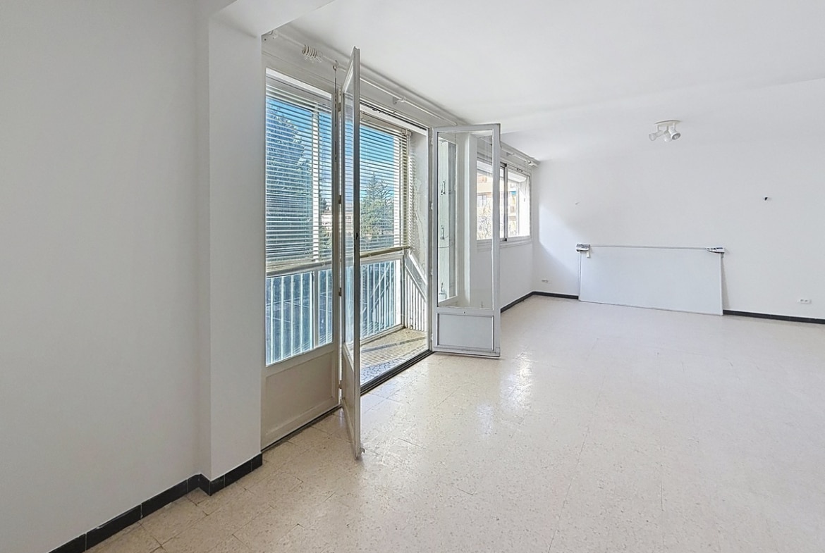 Pièce de vie principale avec espace pour canapé et mobilier, fenêtre apportant la lumière du jour. Séjour aux murs neutres dans un appartement au sein d'une résidence avec ascenseur.