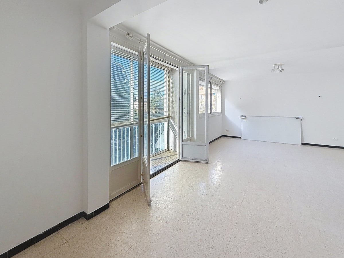 Pièce de vie principale avec espace pour canapé et mobilier, fenêtre apportant la lumière du jour. Séjour aux murs neutres dans un appartement au sein d'une résidence avec ascenseur.