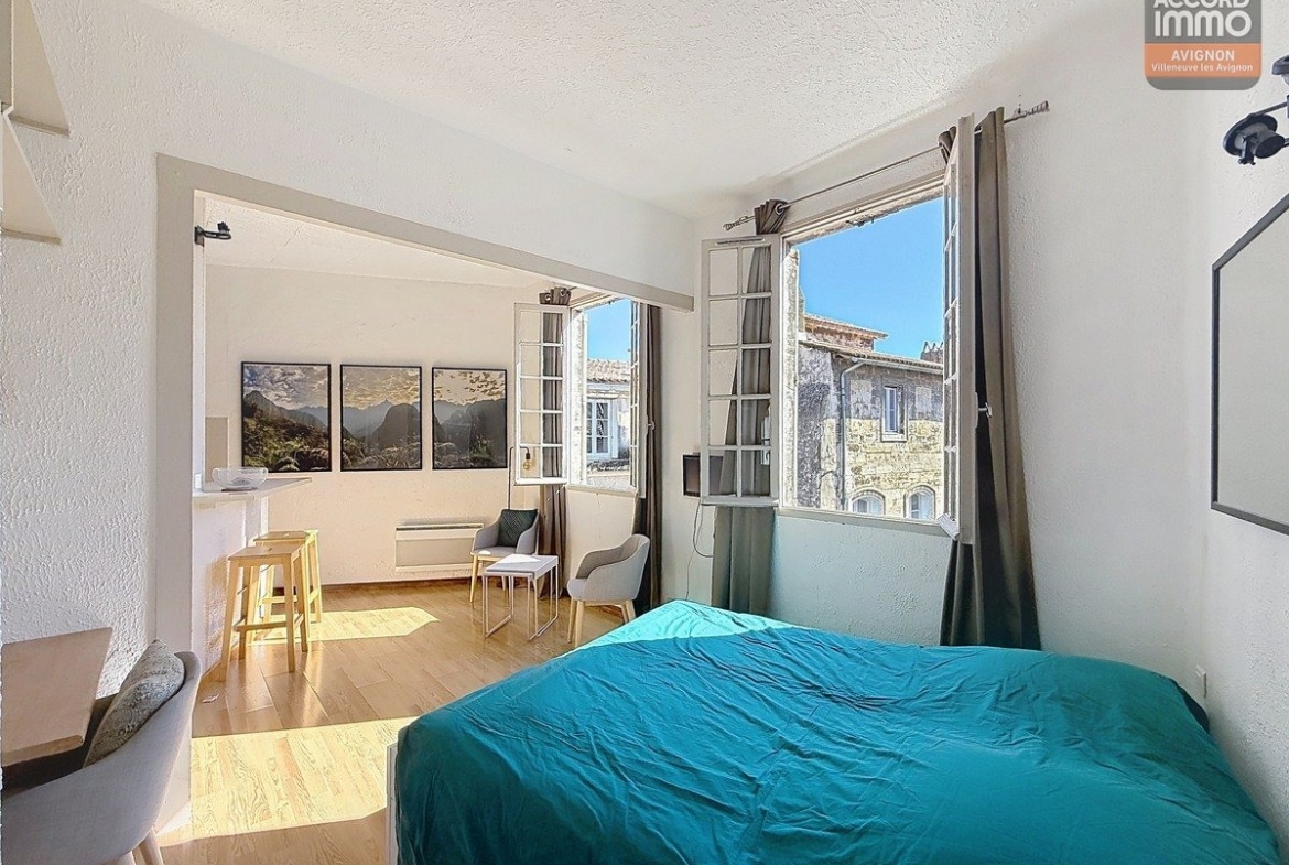 Séjour orienté sud avec fenêtre à huisserie bois, sol en carrelage ou parquet et murs clairs. Espace polyvalent accueillant coin salon et zone repas, hauteur sous plafond standard.